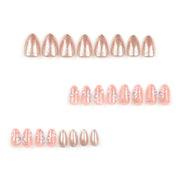 Peach almond press-on nails with sheer peach base, white floral art and rose gold glitter accents